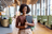 Portrait of happy African businesswoman holding digital tablet standing in the office. Female entrepreneur at her startup office looking at camera and smiling.